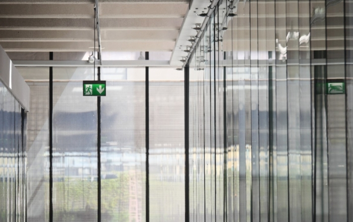 Corridor With Glass Walls And Illuminated Emergency Exit Sign